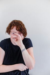 emotional person with hands over their face