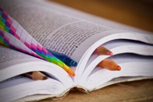 open book with colored tabs and pencils