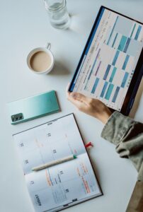 tablet with schedule on screen and appointment book on desk
