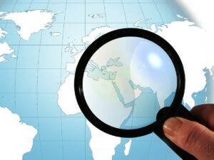 magnifying glass held over countries on a globe