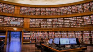 library with books on shelves and computer screens
