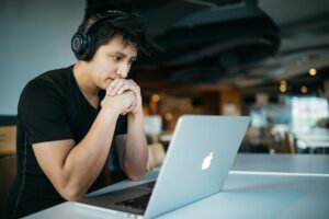 person with headphones looking at laptop