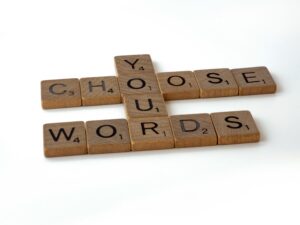 Scrabble tiles spelling the phrase "Choose Your Words"