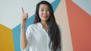 person smiling and pointing upward